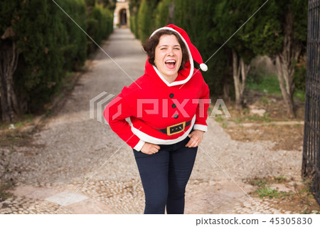 Christmas, holidays, humor and people concept - funny happy woman in santa suit dancing outdoors Christmas, holidays, humor and people concept - funny happy woman in santa suit dancing outdoors 45305830