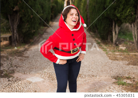 People, emotions and christmas concept - young brunette funny woman in santa suit dancing outdoors People, emotions and christmas concept - young brunette funny woman in santa suit dancing outdoors 45305831