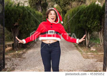 Christmas, holidays, humor and people concept - funny happy woman in santa suit dancing outdoors Christmas, holidays, humor and people concept - funny happy woman in santa suit dancing outdoors 45305852