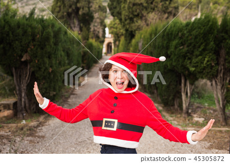 Christmas, holidays, humor and people concept - funny happy woman in santa suit dancing outdoors Christmas, holidays, humor and people concept - funny happy woman in santa suit dancing outdoors 45305872
