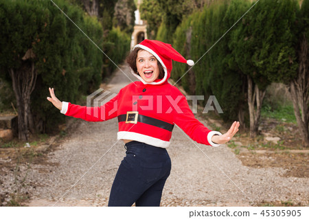 Christmas, holidays, humor and people concept - funny happy woman in santa suit dancing outdoors Christmas, holidays, humor and people concept - funny happy woman in santa suit dancing outdoors 45305905