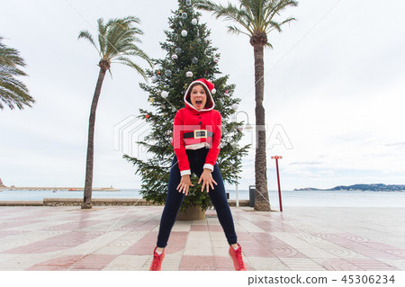 people, holidays and christmas concept - young funny and expressive woman dressed as santa claus people, holidays and christmas concept - young funny and expressive woman dressed as santa claus 45306234