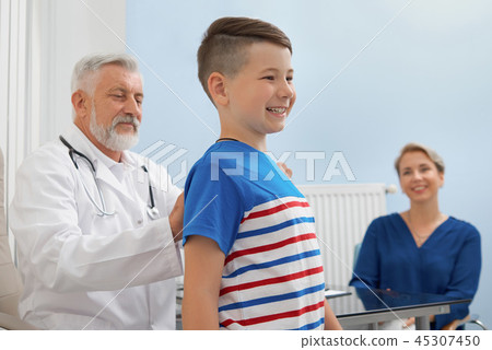 Doctor looking at posture of boy in private clinic. Doctor looking at posture of boy in private clinic. 45307450