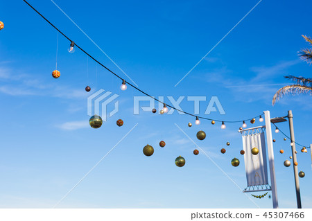 Christmas balls hanging against the blue sky 45307466