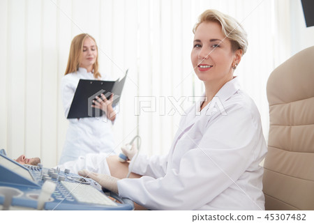 Doctor looking at camera while diagnosing patient. Doctor looking at camera while diagnosing patient. 45307482