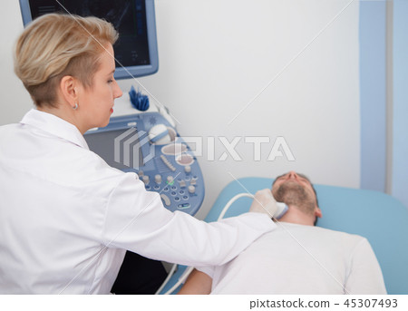 Doctor doing ultrasound diagnosis of patient's neck. Doctor doing ultrasound diagnosis of patient's neck. 45307493