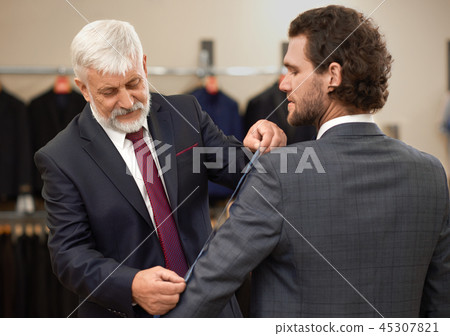 Attractive curly man coming to tailor for new costume. 45307821