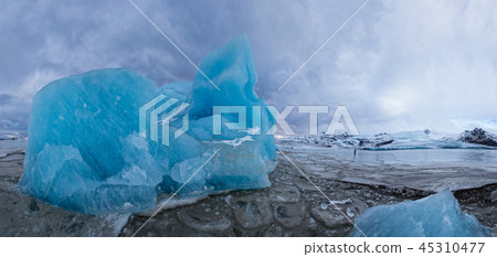 Famous Fjallsarlon glacier and lagoon with icebergs swimming on frozen water. 45310477