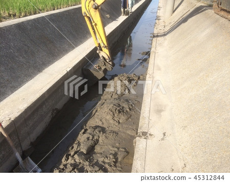 Guttering work in the ditch, removing soil deposited by heavy rain Guttering work in the ditch, removing soil deposited by heavy rain 45312844