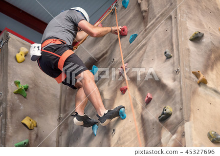 Young man practicing rock climbing Young man practicing rock climbing 45327696