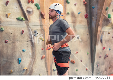 Man climber preparing to climb indoor wall. Man climber preparing to climb indoor wall. 45327711