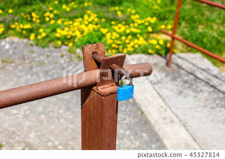 Blue lock on old rusty car ramp, 45327814