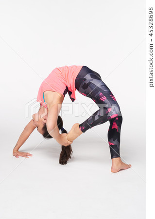 Woman practicing yoga Bridge pose on white 45328698