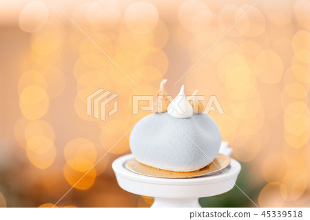 Mini mousse pastry dessert with gray velour on garland lamps bokeh background. Modern european cake 45339518