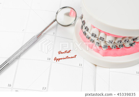 Tooth model with metal wire dental braces. 45339835