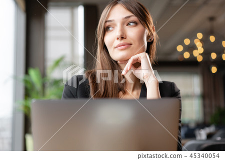 Young woman behind the laptop screen. thoughtfully look away. Girl blogging, browsing internet 45340054