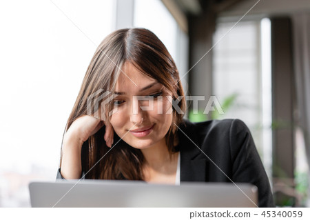 Young woman looks into the laptop screen. Girl blogging, browsing internet, chatting. Sits in coffee Young woman looks into the laptop screen. Girl blogging, browsing internet, chatting. Sits in coffee 45340059
