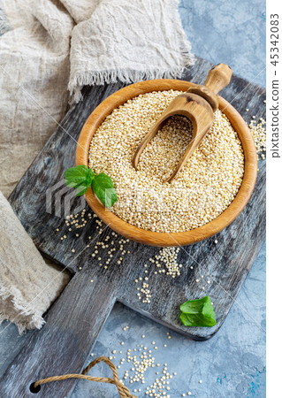 Raw quinoa seeds in the wooden bowl. Raw quinoa seeds in the wooden bowl. 45342083