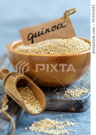 White quinoa in a wooden bowl and scoop. White quinoa in a wooden bowl and scoop. 45342085