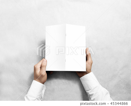 Hand holding blank white brochure mockup, back side view. 45344866