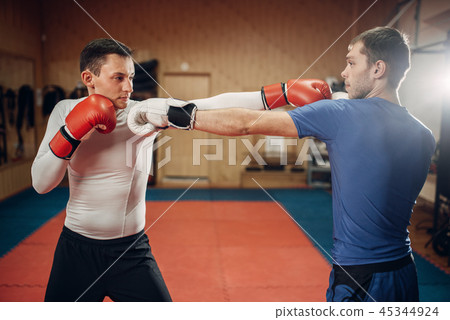 Two male kickboxers practicing on workout in gym 45344924