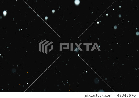 Flakes of snow falling on a black background. Isolated 45345670