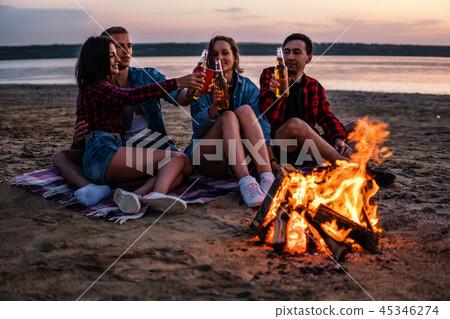 young friends have picnic with bonfire on the beach 45346274