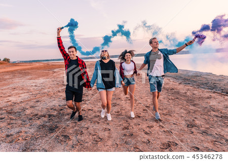 young friends running with hand flare or fusee 45346278