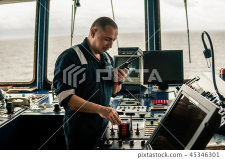 Marine navigational officer is maneuvering ship or vessel Marine navigational officer is maneuvering ship or vessel 45346301