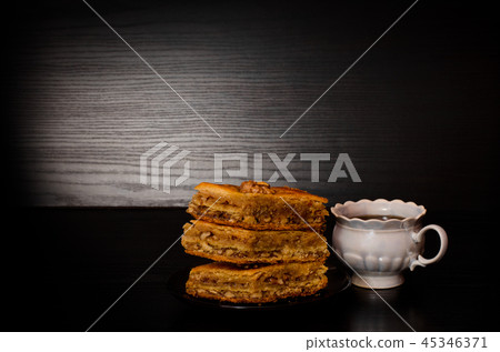 A mug of tea and a plate of Turkish baklava honey A mug of tea and a plate of Turkish baklava honey 45346371