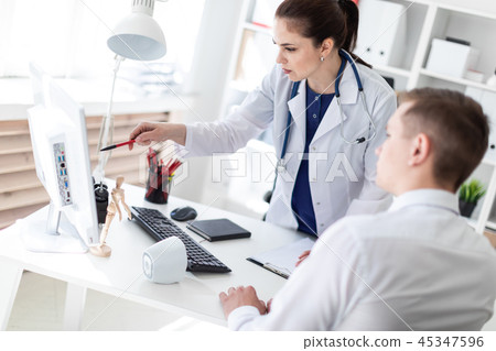 The doctor explains the problem to the patient on the computer. 45347596