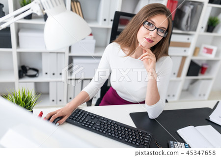Portrait of a young girl at a computer Desk in the office. 45347658