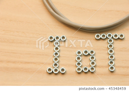 A LAN cable with the letters "IoT" written on a wooden board with a hex nut. A LAN cable with the letters "IoT" written on a wooden board with a hex nut. 45348459
