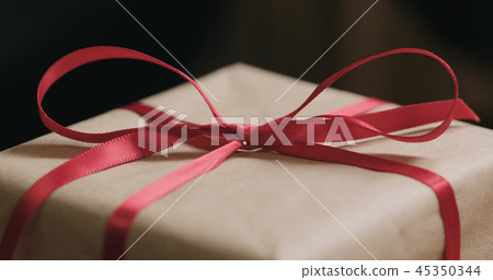 Macro red ribbon bow on craft gift box Macro red ribbon bow on craft gift box 45350344