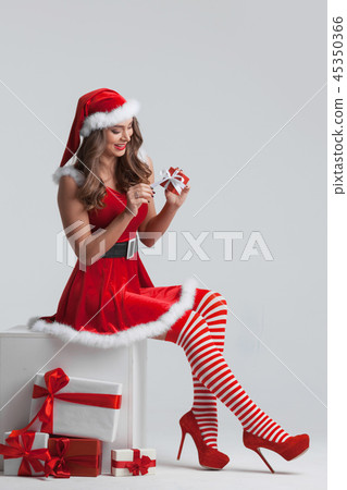 Girl unwrapping christmas present 45350366
