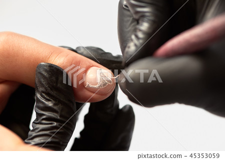 Manicurist hands painting abstract silver glitter design on client nails using applicator brush. Manicurist hands painting abstract silver glitter design on client nails using applicator brush. 45353059