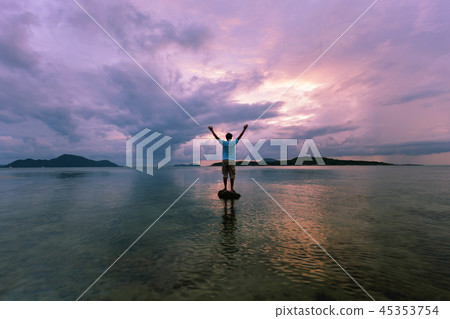 Alone man tourist standing on the stone in the sea 45353754