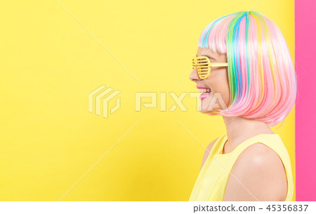 Woman wearing shutter shades sunglasses in a colorful wig 45356837