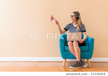 Young woman with UK flag using a laptop computer Young woman with UK flag using a laptop computer 45356859