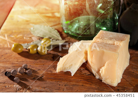 parmesan and olives on wooden surface  45358451