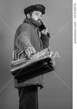 Business man with briefcase is talking on phone 45358979