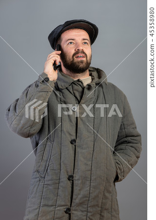 Happy man in old-fashioned clothes speaks by phone 45358980