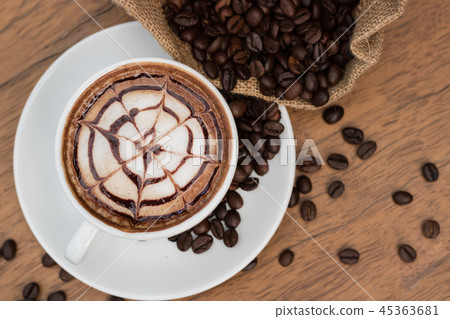 Hot coffee and coffee beans on wooden table. Hot coffee and coffee beans on wooden table. 45363681