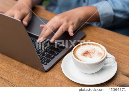 Hands typing on laptop in coffee shop 45364871