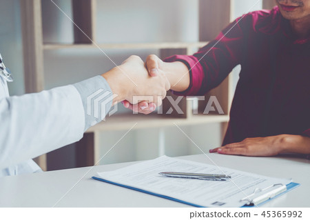 Confident Doctor shaking hands with patients  45365992