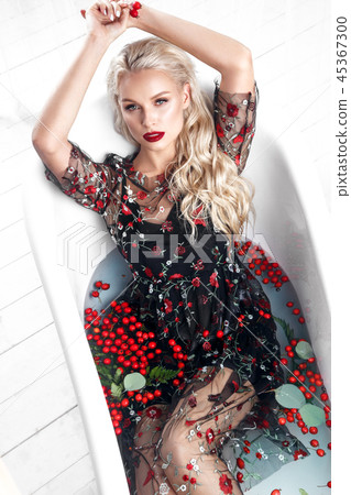 Beautiful girl in a summer dress in the bathroom with flowers. Beauty face. Beautiful girl in a summer dress in the bathroom with flowers. Beauty face. 45367300