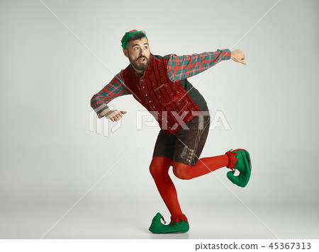 friendly man dressed like a funny gnome posing on an isolated gray background friendly man dressed like a funny gnome posing on an isolated gray background 45367313