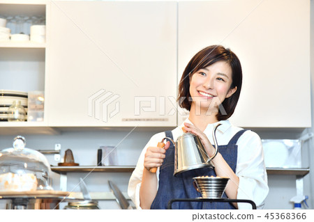 A woman in a cafe serving drip coffee 45368366