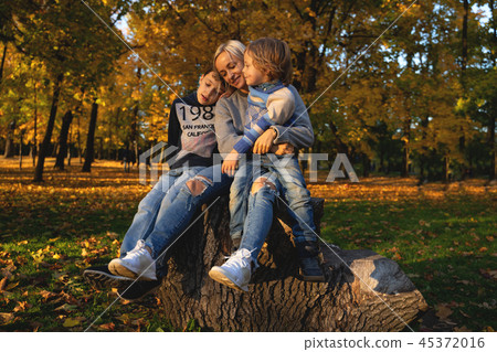 Smiling young family into leaves on an autumns day 45372016