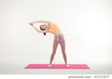 A Korean woman doing yoga exercise on mat A Korean woman doing yoga exercise on mat 45372877